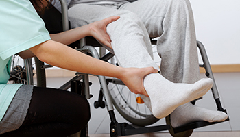 A nurse assists a man in a wheelchair