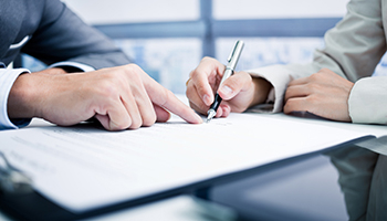 Two business people focused on signing a document